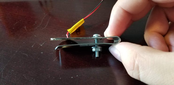 Piezoelectric sensor and clip with adjustment screw.