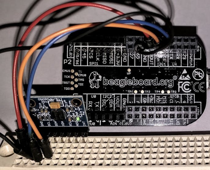 An accelerometer board (left) can be connected to the PocketBeagle's I2C port with four wires.