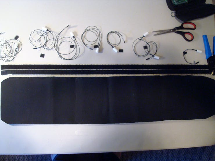 Now collect all the finished tactor cable assemblies and lay them out in the proper positions, using the markings on the opposing side as a guide. Since we want the tactors to be completely surrounded, cut out a section of velcro about the length of the belt.