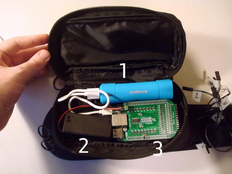 Now that the case and the belt are connected, it's time to load all the parts we need to run the Cape+BeagleBone off the grid. 1: Smartphone battery pack. 2. AA x 2 battery pack to power the tactors. 3: The BeagleBone with Haptic Cape attached.